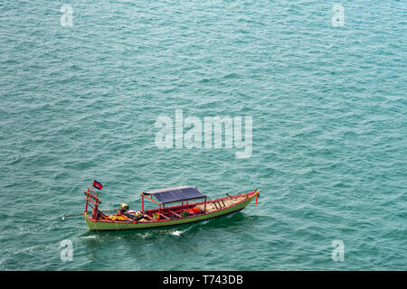 Sihanoukville, Cambogia - Marzo 15, 2019: piccolo verde e rosso sloop di pesca sul mare di colore verdastro acqua fuori Sihanouk Porto autonomo. Foto Stock