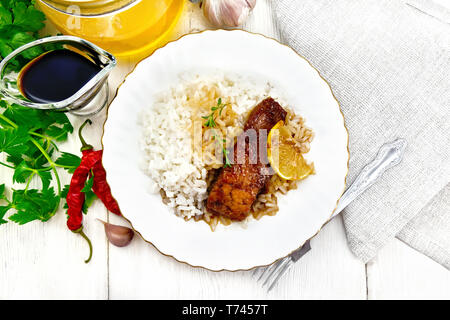 Rosa salmone con il miele, il succo di limone e salsa di soia, riso bollito, fetta di limone e rametto di timo in una piastra, peperoncino, aglio, prezzemolo, igienico e Foto Stock