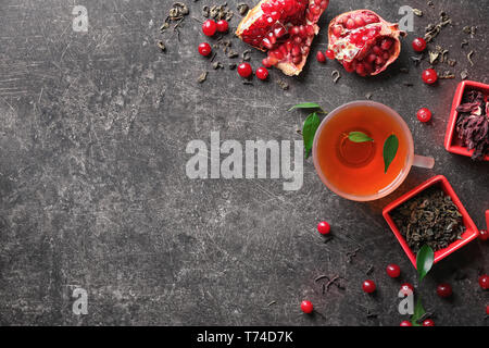 Composizione con coppa di vetro di acqua calda tè aromatico su tavola Foto Stock