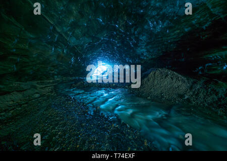 Guardando verso l'entrata di una caverna di ghiaccio mentre è a 500 metri al di sotto di un ghiacciaio; Islanda Foto Stock