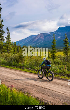 Un uomo grasso in bicicletta sulla strada Nabesna in Wrangell-St. Elias National Park e conservare in un nebbioso giorno di estate nel centro-sud della Alaska Foto Stock