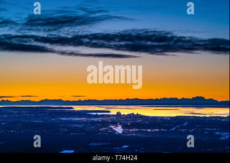 Anchorage in Alaska, come visto da Arctic Valley Road mentre il sole tramonta su un inverni di notte. La Insenatura Cook e l'Alaska Range sono in background Foto Stock
