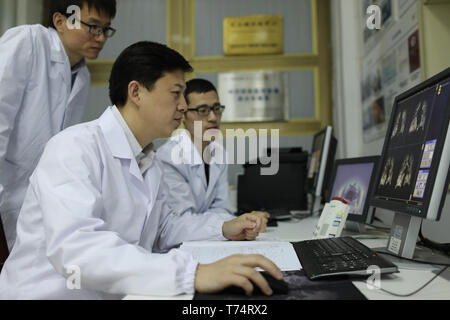 (190504) -- WUHAN, 4 maggio 2019 (Xinhua) -- Xin Zhou (C) discute con i suoi colleghi circa la qualità del polmone umano immagini di risonanza magnetica a Wuhan Istituto di Fisica e Matematica dell'Accademia cinese delle scienze di Wuhan, capitale della Cina centrale della provincia di Hubei, 18 aprile 2019. Professore di Xin Zhou è il vice direttore di Wuhan Istituto di Fisica e Matematica dell'Accademia cinese delle scienze, chiave dello stato Laboratorio di risonanza magnetica e la fisica atomica e molecolare, e il Centro Nazionale per la risonanza magnetica nucleare a Wuhan. Egli è interessato a ultrasensitive risonanza magnetica imagin Foto Stock