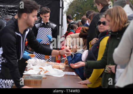 Serve hamburger all'aperto presso la Fiera del centro di Cuckoo, vicino a Salisbury, Regno Unito, 4th maggio 2019. Affollata bancarella di hamburger alla fiera annuale che si svolge lungo il Borough nel villaggio del South Wiltshire. L'evento è frequentato da migliaia di persone ogni anno. Foto Stock