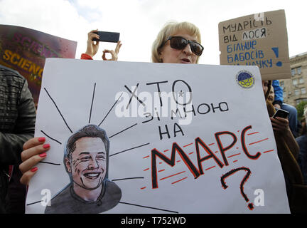 Kiev, Ucraina. Il 4 maggio, 2019. Una donna che tiene un poster con un'immagine del CEO di SpaceX e Tesla Motors Inc. Elon Musk e la lettura come "Chi è con me su Marte?" durante il mese di marzo in costume per la scienza nel centro di Kiev, Ucraina, il 4 maggio 2019. Popularizers della scienza, i fisici e i seguaci della scienza ha preso parte al 'Marco per la scienza' azione globale per la libertà di ricerca e di insegnamento nel corso di manifestazioni che hanno avuto luogo in tutto il mondo il sabato il 4 maggio. Credito: Serg Glovny/ZUMA filo/Alamy Live News Foto Stock