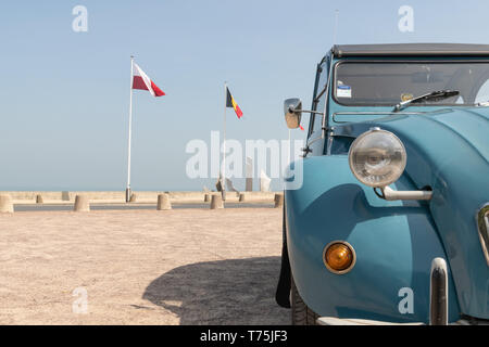 Auto d'epoca francese in blu con bandiera francese sullo sfondo. Una bella vintage 2CV fotografata dalla parte anteriore. Foto Stock