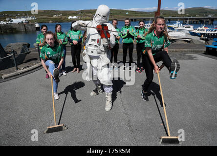 Membro della '501Legion Irlanda Garrison' Christy Healy vestito come un 'ora' Trooper con membri del sud Gaels GAA club come ballano per raccogliere fondi, durante il Maggio 4 Festival in Portmagee, dove le scene di Star Wars sono state filmate. Foto Stock