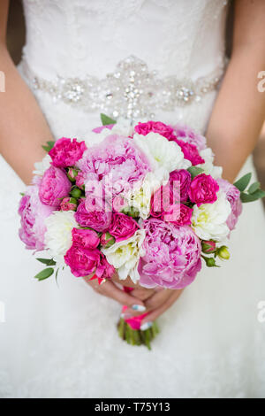 Irriconoscibile sposa tenendo un matrimonio raffinato bouquet di rose e peonie Foto Stock