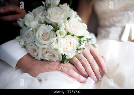 Nozze squisito bouquet di rose bianche e fresia sulle mani di sposi Foto Stock