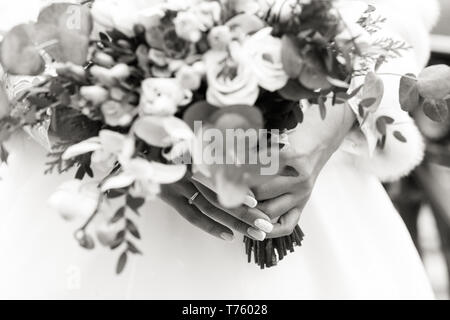 Squisito Bouquet nozze nelle mani di un irriconoscibile sposa, in bianco e nero shot Foto Stock