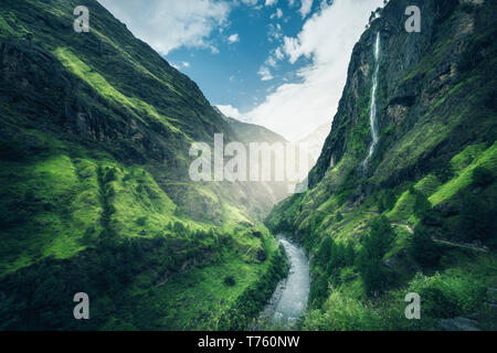 Belle montagne coperte di erba verde. Moody paesaggio con mountain valley, fiume, cascata, prati e foreste, sky con le nuvole in estate a Nepa Foto Stock
