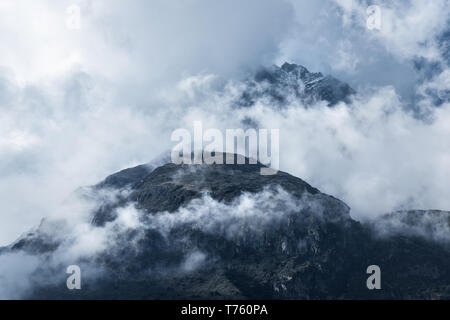 Majestical montagne in nubi in serata a sopraggitto in Nepal in estate. Paesaggio con belle e alte rocce e drammatico cielo nuvoloso. La natura dello sfondo. Foto Stock