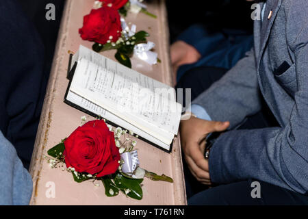 Novi Sad Serbia - 28 Aprile 2019: l'inno anglicana prenota e rose rosse nella chiesa Foto Stock