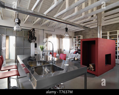 Scatti di interni di un moderno attico in primo piano la cucina in acciaio isola con lavandini in acciaio integrato Foto Stock