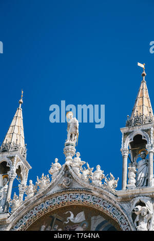 Close up di statue sulla parte superiore della Basilica di San Marco la Basilica di San Marco a Venezia, Italia. Golden dettaglio di lusso di facciata in estate contro blu sk Foto Stock