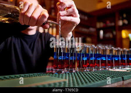 Scatti alcolica sul bancone. Professional Bartender versa scatti alcolica. Foto Stock