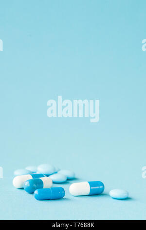 Blu pillole e capsule su sfondo blu con una copia dello spazio. Foto Stock