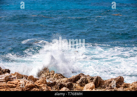 Oceano onde si infrangono sulla costa rocciosa del Grand Fond, St Barts Foto Stock