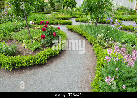 La progettazione paesaggistica. Il pietrisco e percorsi di siepe bassa frontiere in formale, vecchio giardino Foto Stock