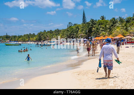 Le persone che si godono la spiaggia di West Bay Roatan Honduras su una bella e soleggiata giornata di aprile. Foto Stock