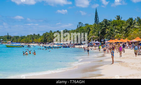 Le persone che si godono la spiaggia di West Bay in Roatan Honduras su una soleggiata giornata di aprile. Foto Stock