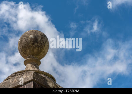 In alto di un gateway decorativo pilastro. Cielo blu e nuvole bianche dietro. Foto Stock