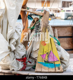 Un colorato raffigurazione di una imbarcazione a vela dipinte su legno di scarto in Gustavia, St Barts Foto Stock