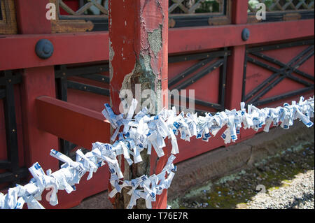 Tokyo, Giappone - Aprile 2019: preghiere su carta, infilate fino ad un sacrario scintoista. Foto Stock