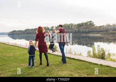 Paternità e maternità, infanzia, concetto di persone - famiglia passeggiate vicino al fiume Foto Stock