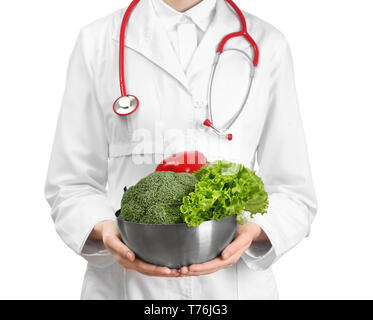Medico donna tenendo la coppa con verdure sane su sfondo bianco Foto Stock