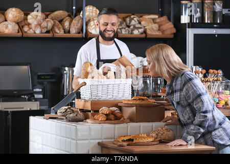 Giovane donna scelta di pasticceria da forno Foto Stock
