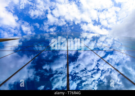 Nuvole e cielo blu riflessa sul vetro edificio per uffici di windows Foto Stock