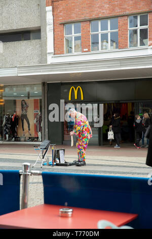 Salvo il clown. Un clown freelance si sta preparando per le prestazioni nel centro della città di fronte a McDonald's. Marzo, 2019, Southend-on-Sea, Regno Unito. Foto Stock