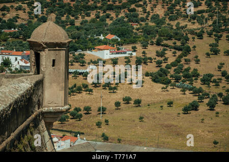 Torre di avvistamento su un muro di fortificazione di fronte a un paesaggio rurale con case coloniche a Elvas. Una graziosa città sulla frontiera più orientale del Portogallo. Foto Stock