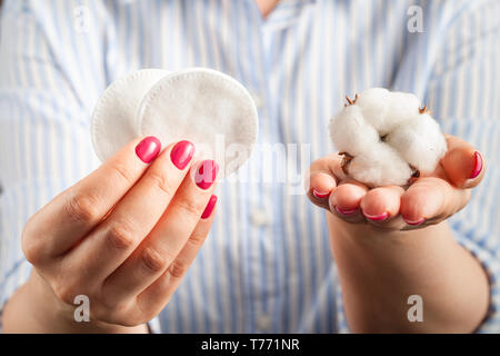 Soffice batuffolo di cotone e bastoncini di cotone e pastiglie in mani Foto Stock