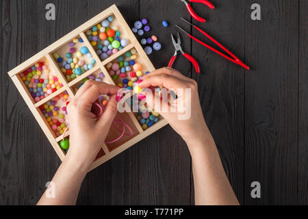 Pulsante fatti a mano braccialetto. Set di luminose pulsanti colorati, pinze. DIY bangle gioielli idea. Facile fare artigianato creativo Foto Stock