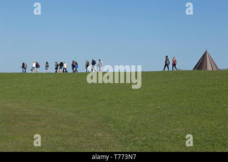 La gente camminare sulla diga, Spiekeroog Island, East Friesland, Bassa Sassonia, Germania Foto Stock