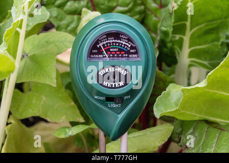 Un misuratore di suolo che mostra il PH in un giardino. Foto Stock