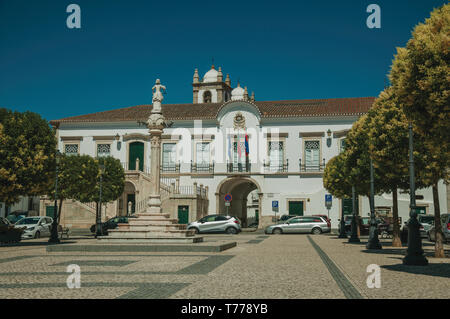 Gogna in marmo in piazza con alberi, pali della luce e il Municipio in background in Campo Maior. Una città medievale con influenze orientali in Portogallo. Foto Stock