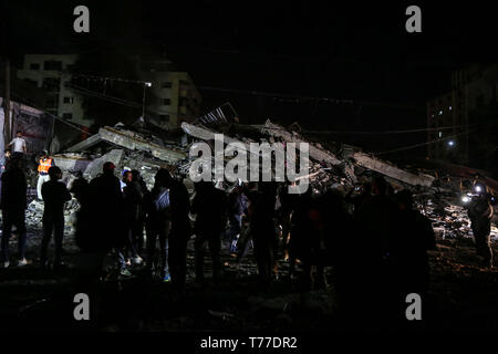 La striscia di Gaza, la Palestina. Il 4 maggio, 2019. Palestinesi ispezionare le macerie di una a sei piani edificio civile colpita da aeroplani militari israeliane missili di Gaza City, 4 maggio 2019. Il numero di morti di sabato è aumentato di quattro e più di 20 altri sono stati feriti durante il corso dell'esercito israeliano gli attacchi aerei sulla striscia di Gaza. Credito: Xinhua/Alamy Live News Foto Stock