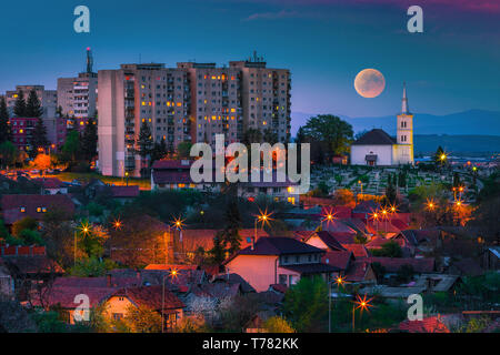 Pittoresca scena serale. Panorama della città di notte con la luna piena, Sfantu Gheorghe, Transilvania, Romania, Europa Foto Stock