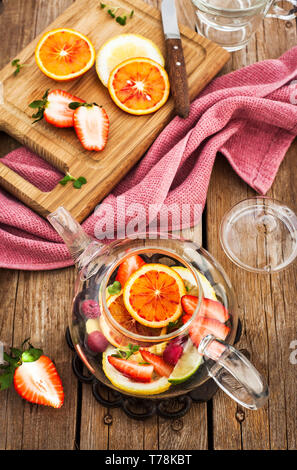 Frutta tè rosso con arance e bacche sul tavolo di legno, vista dall'alto Foto Stock