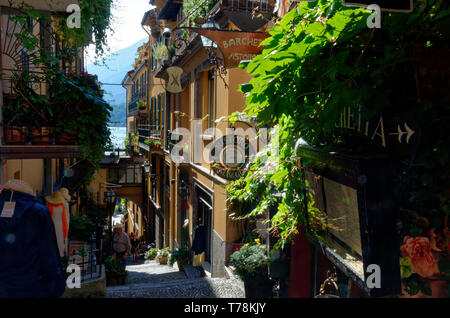 I turisti sulle scale in ciottoli di un elegante, se ripida viuzza a Bellagio, una pittoresca cittadina sulle rive del lago di Como, Italia Foto Stock