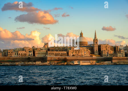 Classic vista da cartolina alla Basilica di Nostra Signora del Monte Carmelo e di San Paolo Pro-Cathedral. La Valletta, Malta. Sky con belle nuvole, Rosa tramonto Foto Stock