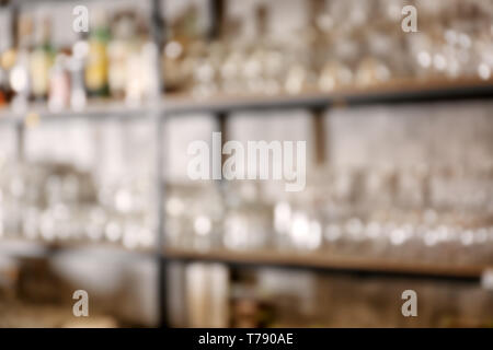 Vista offuscata di vetreria sugli scaffali nel moderno bar Foto Stock