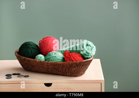 Cesto in Vimini con maglia filettature sul tavolo di legno Foto Stock