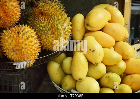 Chiudere il gruppo di mango e durian all'interno di un mercato in tinta, Vietnam Foto Stock