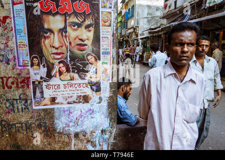 Dacca in Bangladesh : sta un uomo da un Dhallywood ( il film del Bangladesh industria) movie poster in Shankhari Bazaar aka strada indù uno dei più vecchi Foto Stock