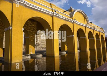 Lavanderia pubblica fontana, Tanque lavadero el Parque la Unione europea, con l'architettura coloniale spagnola archi giallo nella città vecchia Antigua Guatemala Foto Stock