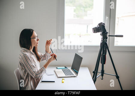 Ragazza di blogger di video online o l insegnante di lingua straniera scrive un video di formazione per gli utenti di caricare a reti sociali. Foto Stock